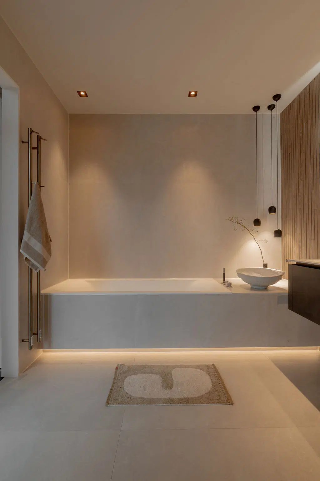 Impressie van een Japandi badkamer, voorzien van een zwevend inbouwbad met verlichting onder het bad.