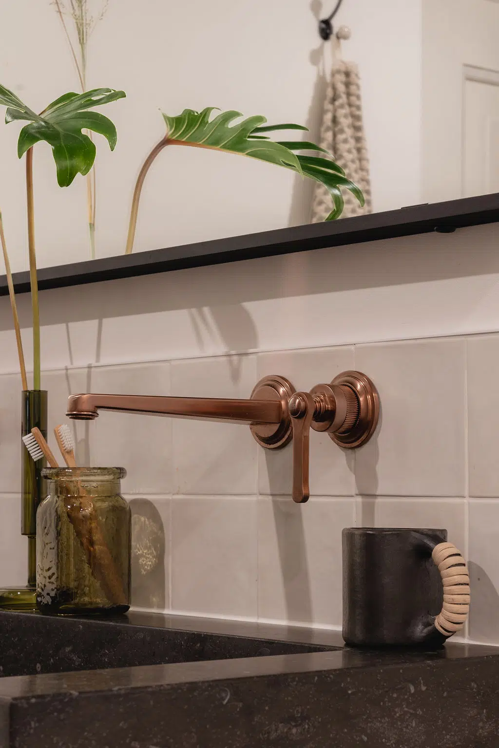 Close-up van een Gessi kraan, gemonteerd aan een wand van Hollandse witjes.