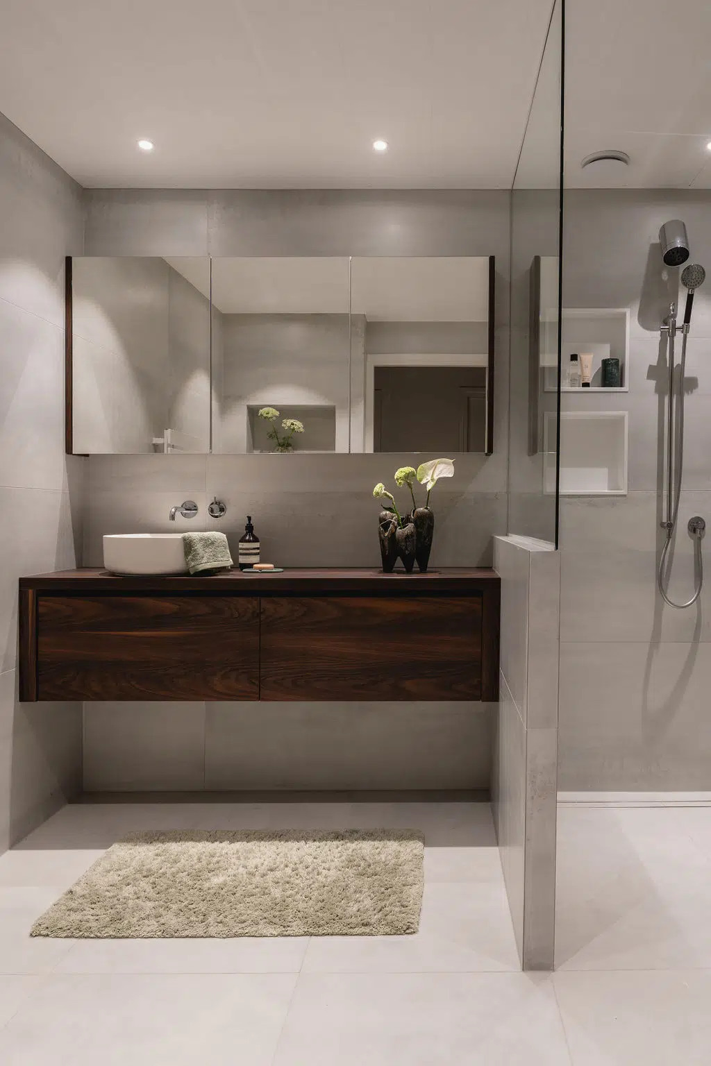 Impressie van een Hotel Chique badkamer met groen marmer, een houten badkamermeubel en een uniek gevormde inbouw douche.
