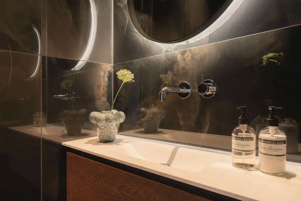 Impressie van een toiletruimte met een zwevend meubel met keramisch wastafelblad en houten onderkast.