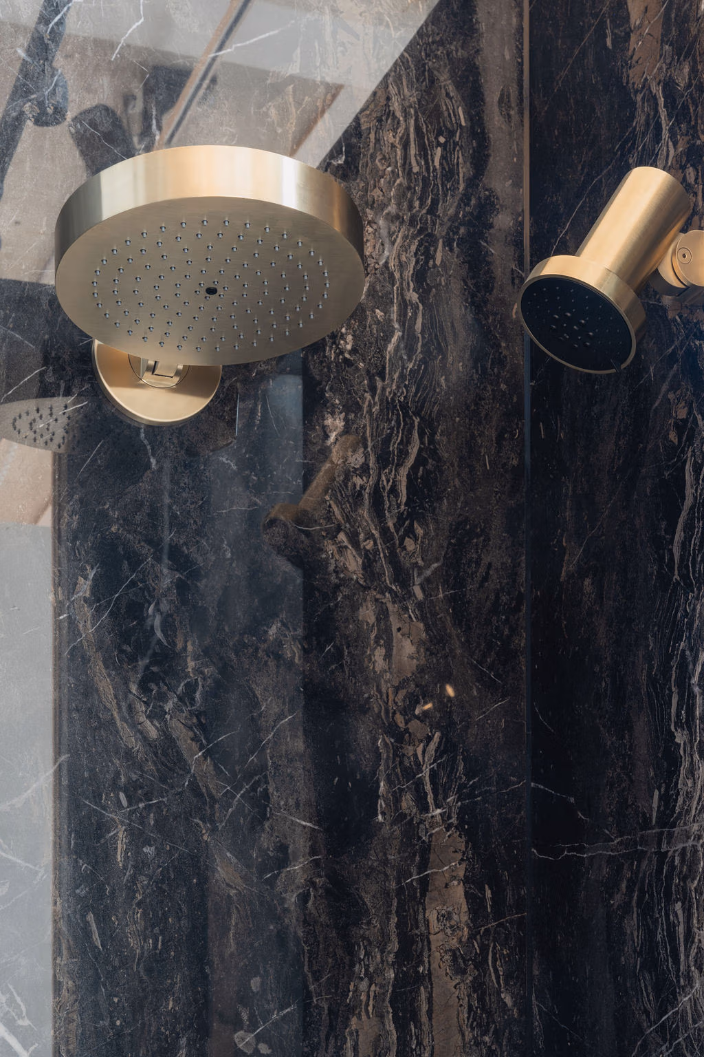 Impressie van een Gessi regendouche en Gessi spotwater douchekop.